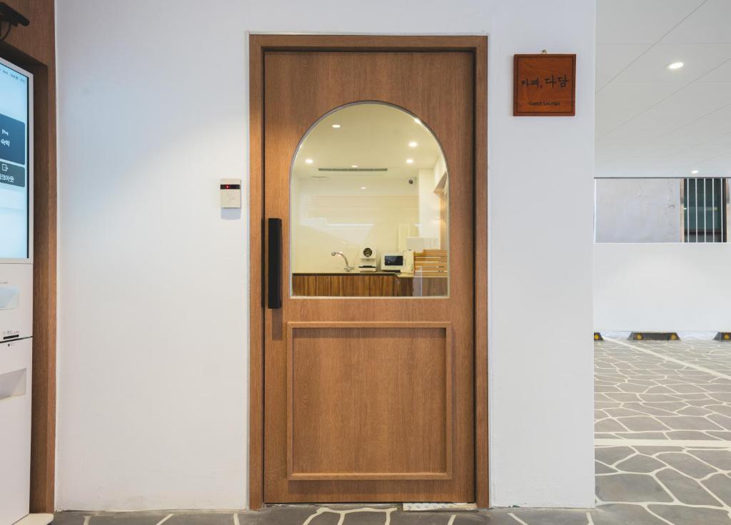 a wooden door with a mirror on a wall at DadamHotel in Suwon