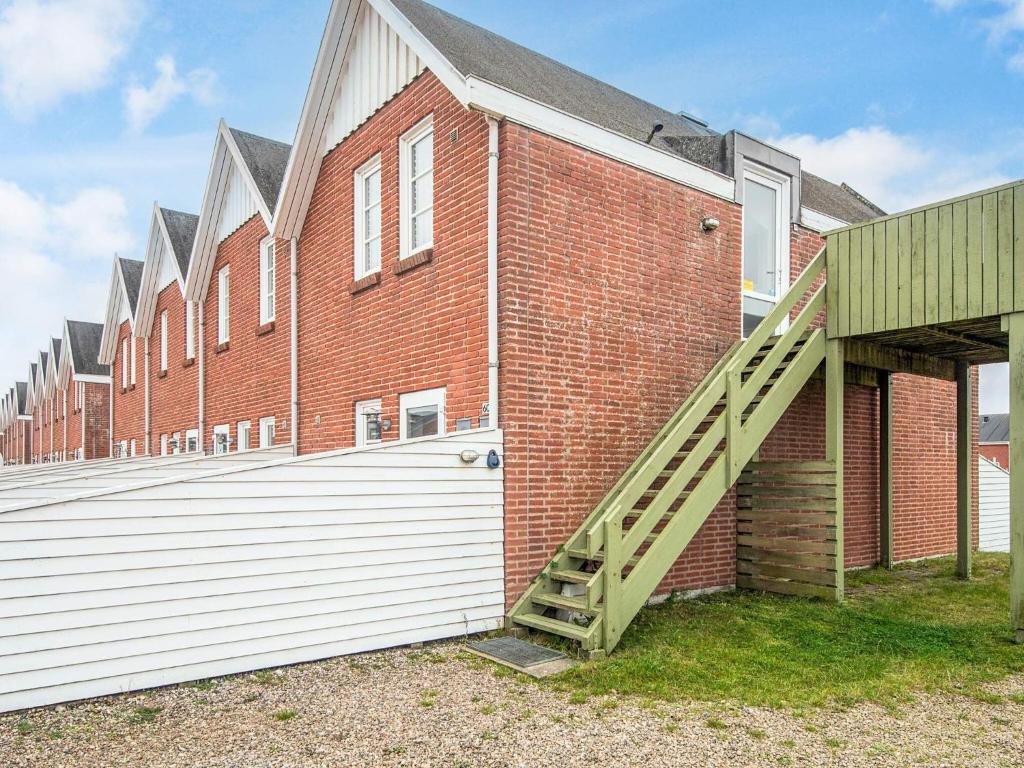 ein Backsteingebäude mit einer Seitentreppe in der Unterkunft 4 person holiday home in Rømø-By Traum in Sønderby