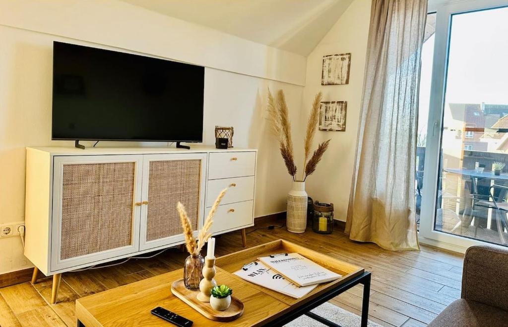 a living room with a flat screen tv and a table at Havnkoje 2 in Westerbergen