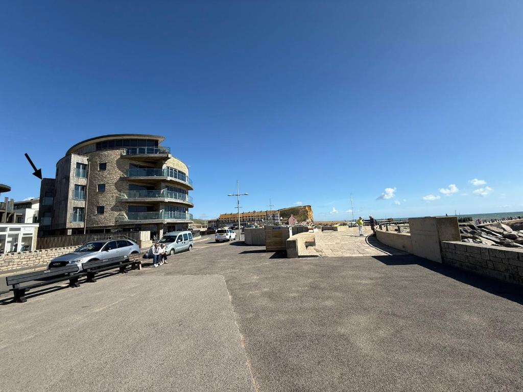 un parking avec des voitures garées devant un bâtiment dans l'établissement Octopus, à West Bay