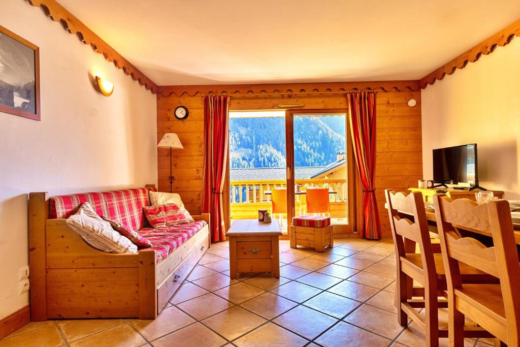 尚帕尼恩瓦努瓦茲Bijolin 4/6 personnes, Spa & Terrasse的带沙发、电视和窗户的客厅