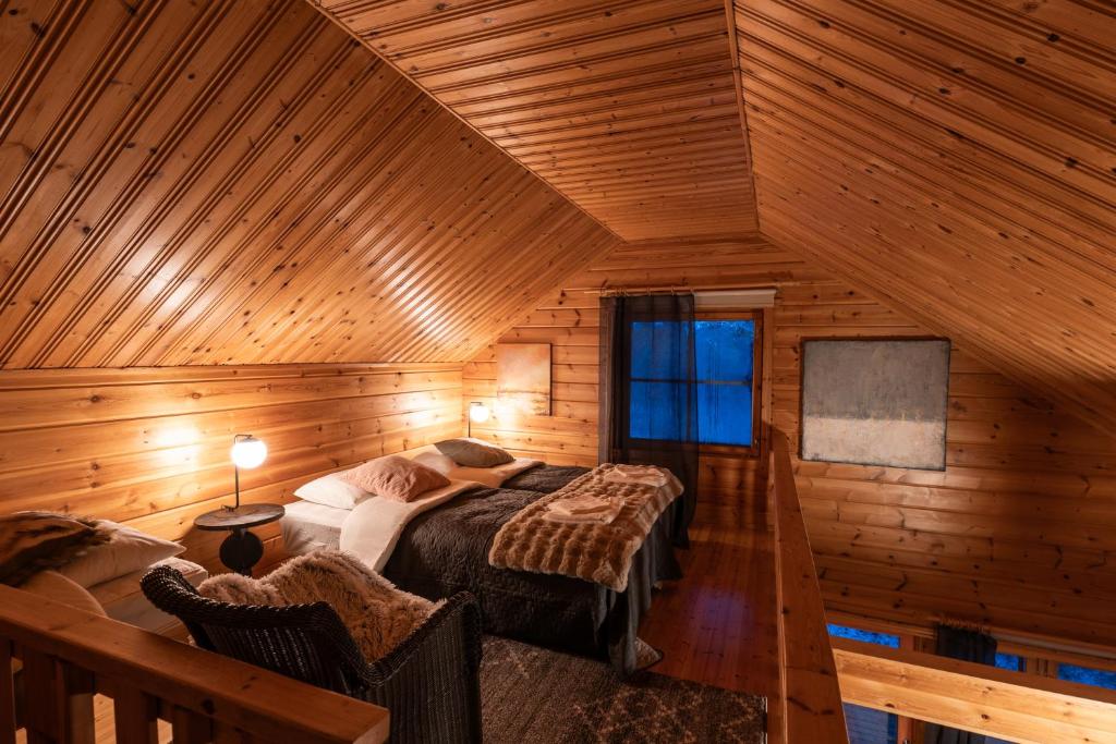 una camera da letto con un letto in una cabina di legno di Arctic Bear Resort - Lapland - Aurora suite - Sauna - Northern Lights a Ranua