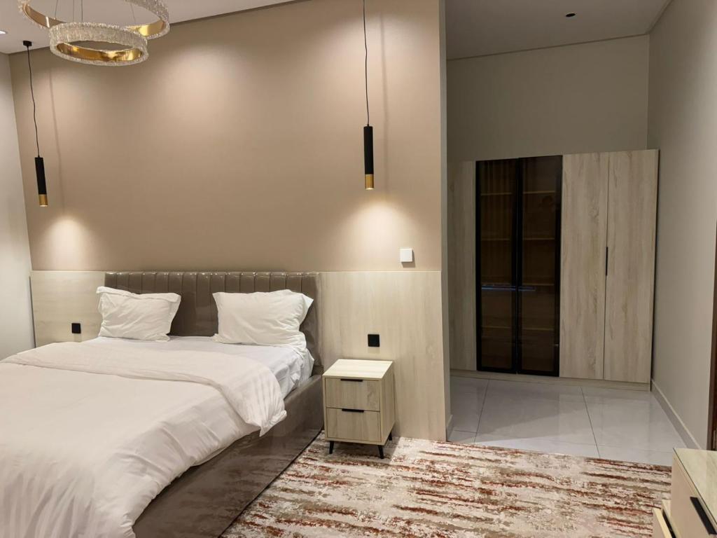 ein Schlafzimmer mit einem Bett, einem Tisch und einem Spiegel in der Unterkunft دايموند جدة للشقق الفاخرة in Dschidda