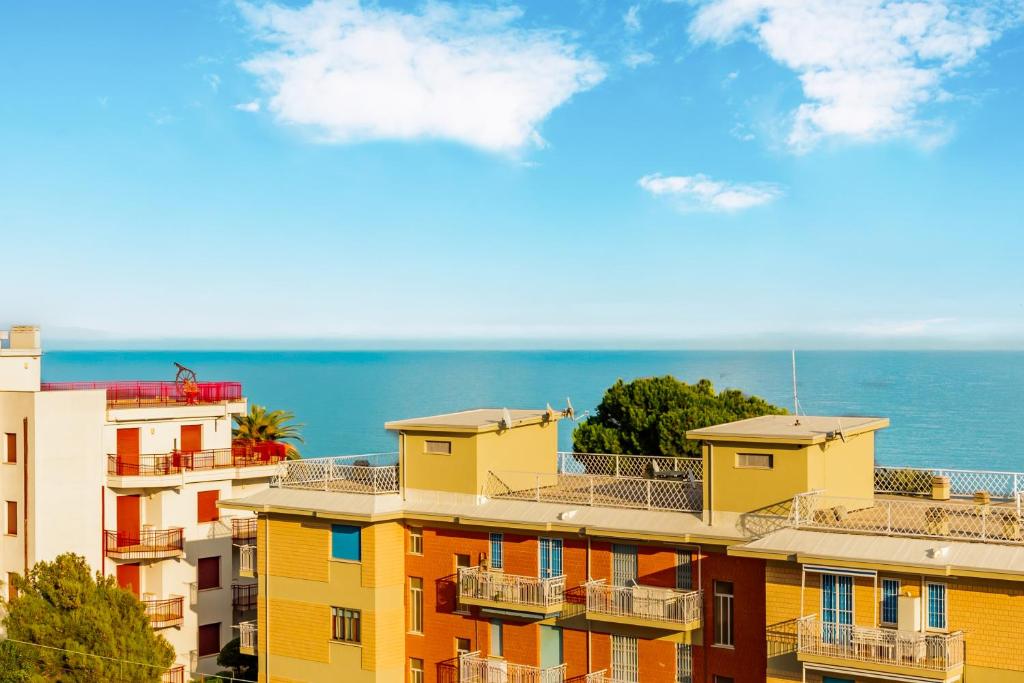 un gruppo di edifici con l'oceano sullo sfondo di Blue Sky House a Ceriale