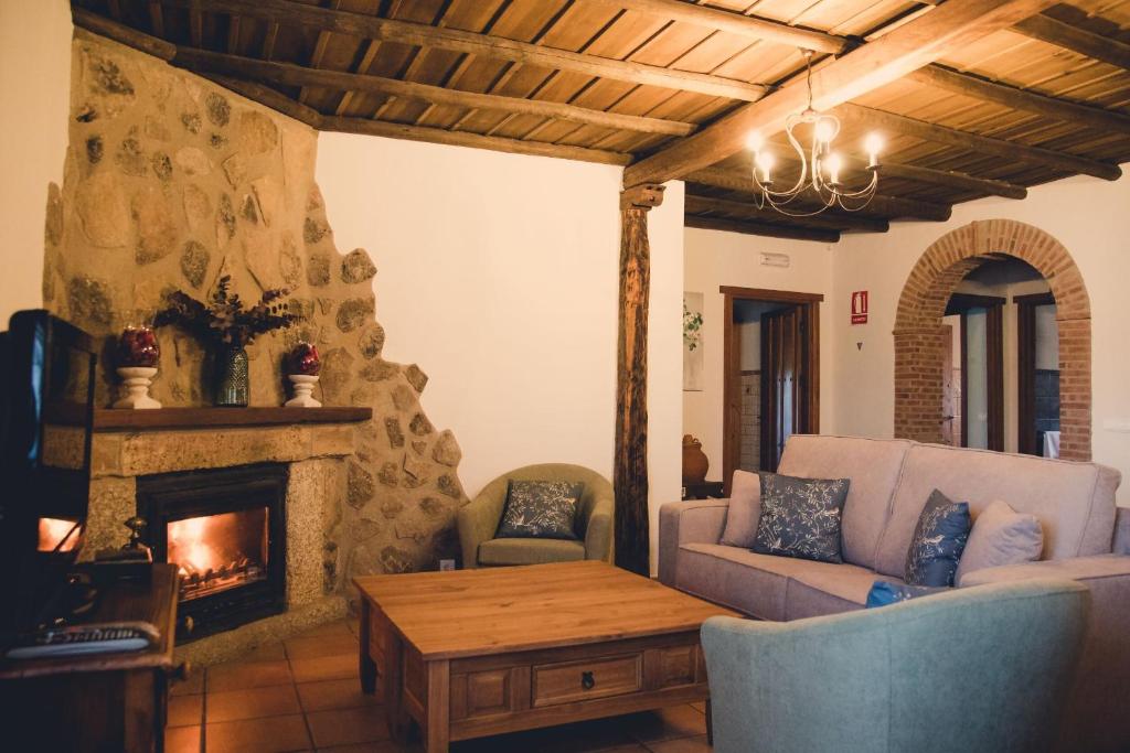 a living room with a couch and a fireplace at Casa Rural La Vega Piscina, naturaleza y vistas in San Vicente de Alcántara
