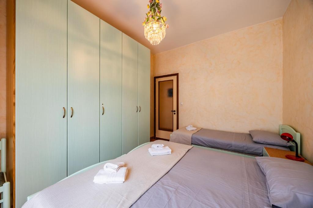 a bedroom with two beds and a chandelier at Blue Sky House in Ceriale