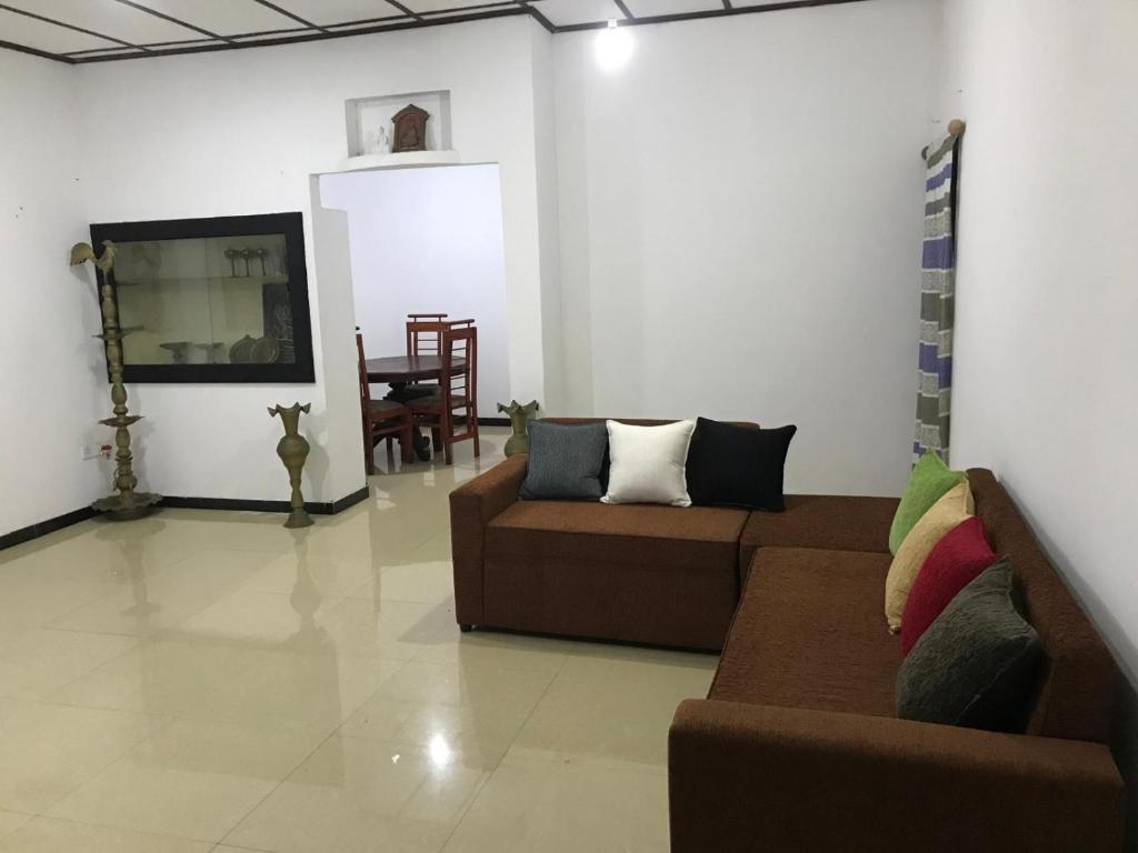 a living room with two couches and a tv at Golden Gate Ways Villa in Hikkaduwa