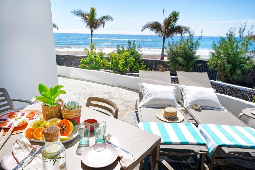 a table with food and a view of the beach at Amapola Palms - recién reformado, frente al mar in San Agustin
