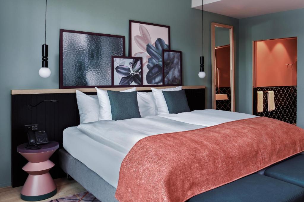 a bedroom with a large bed with a red blanket at Sorell Boutique-Hotel St Peter Zürich in Zürich
