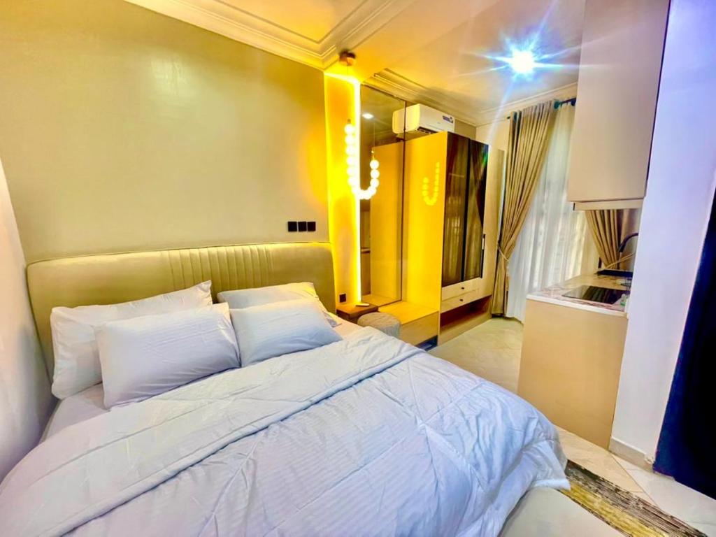 Un dormitorio con una cama grande con almohadas blancas. en Royal Empire, en Abuja