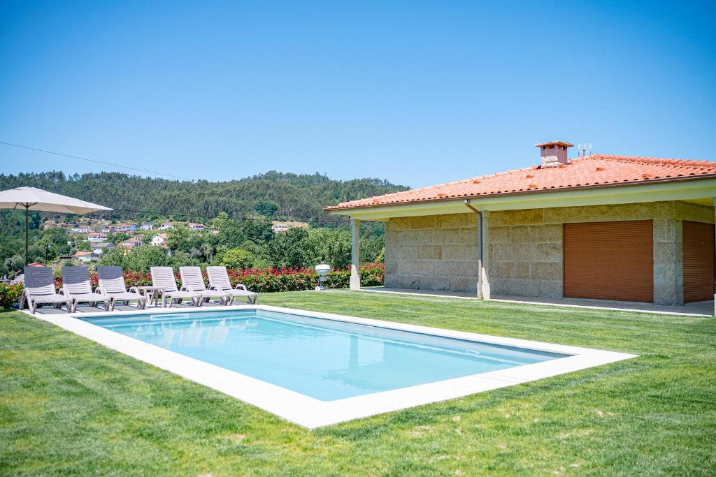 ein Schwimmbad in einem Hof neben einem Haus in der Unterkunft Brook House in Vieira do Minho
