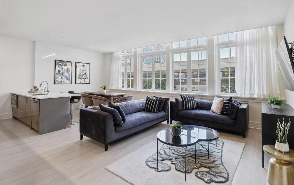 a living room with two couches and a table at The Theodore New Orleans in New Orleans