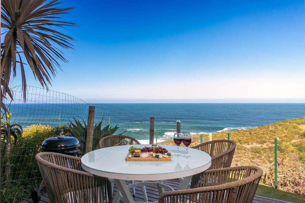 a table with a bowl of fruit and glasses of wine at Knysna, Pezula Golf Estate in Knysna