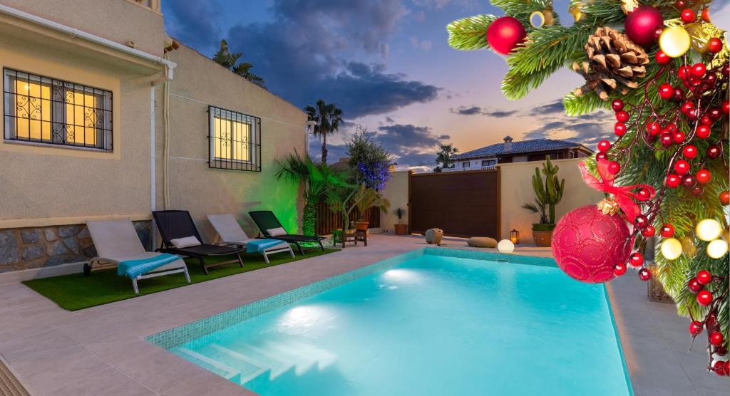 a swimming pool in front of a house with a christmas tree at Fidalsa Coastal Soul in Torrevieja