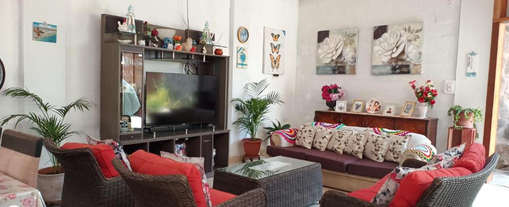 ein Wohnzimmer mit Sofa und Fernseher in der Unterkunft Casa cerca a la playa in Mala