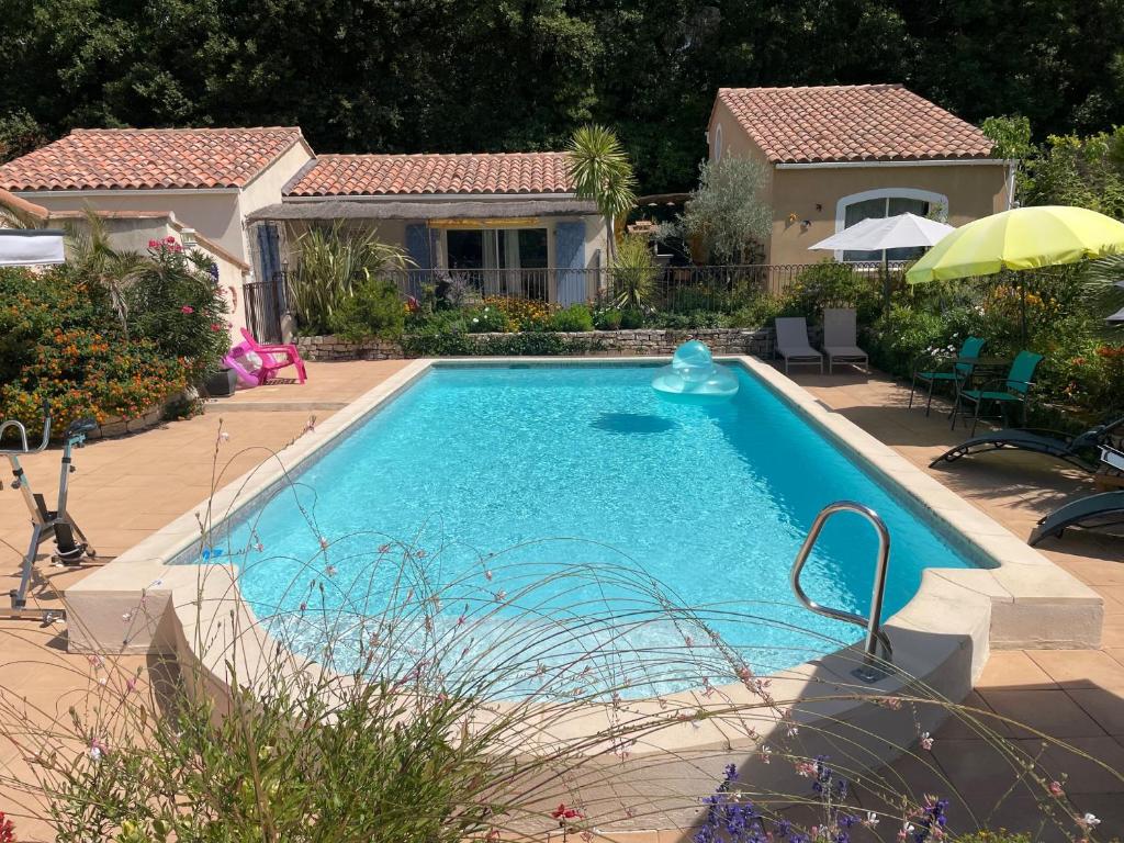 a swimming pool in front of a house at Les Hauts d'Eyragues gîte Aigue Marine Meublé classé 4 étoiles in Eyragues