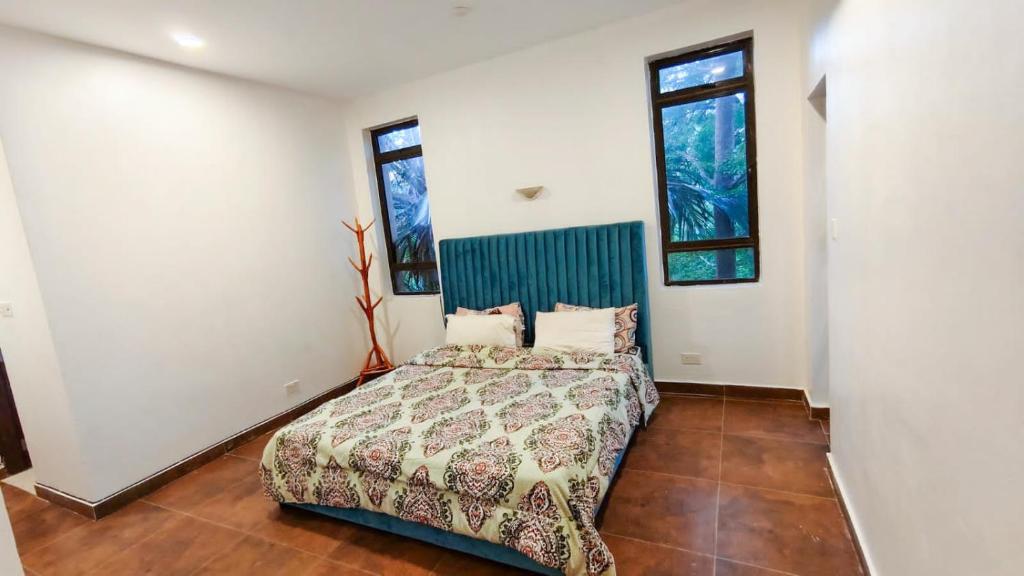 a bedroom with a bed and two windows at Zahra Paradise in Mombasa