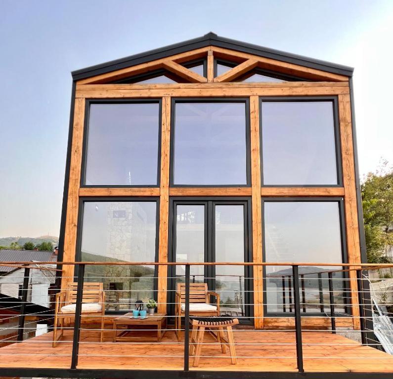 a house with a large window on a deck at Mountain Log Cabin in Mavrovo