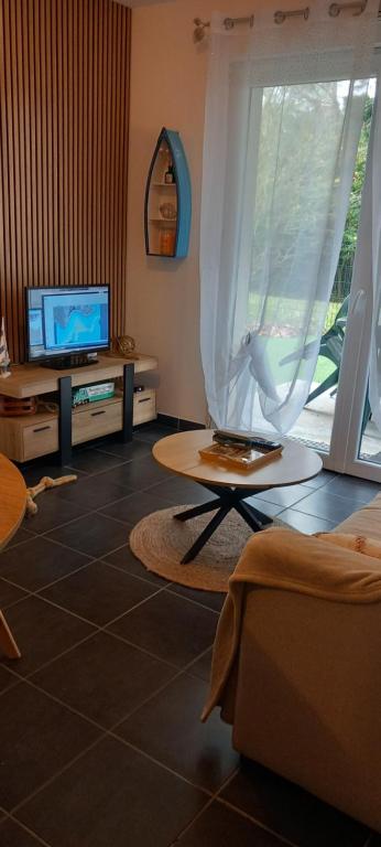 a living room with a tv and a table at Appartement Lanton in Lanton