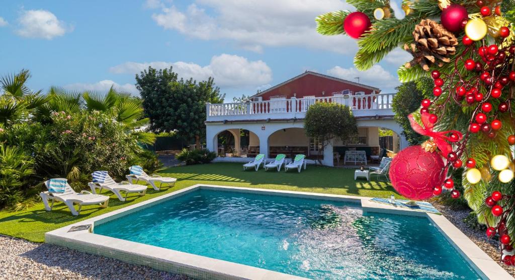una piscina frente a una casa con un árbol de Navidad en Fidalsa Divine Hiding, en Algorfa