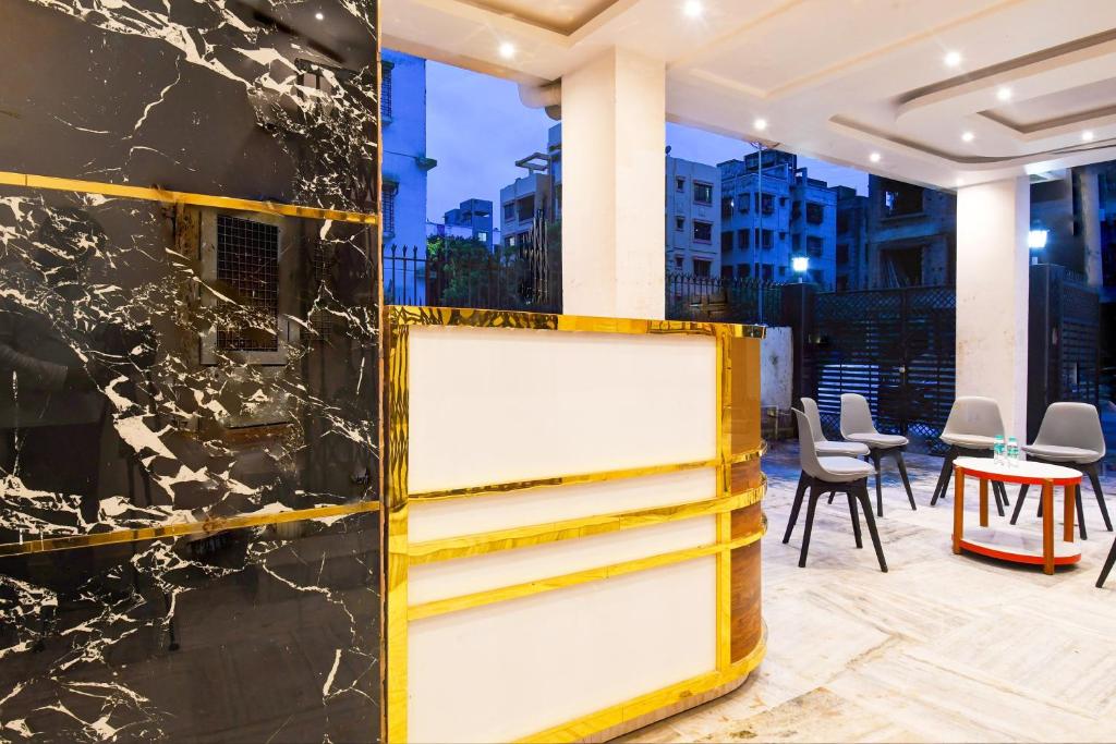 Un vestíbulo con una pared de mármol amarillo y negro en Super Hotel O HAVEN INN, en Calcuta