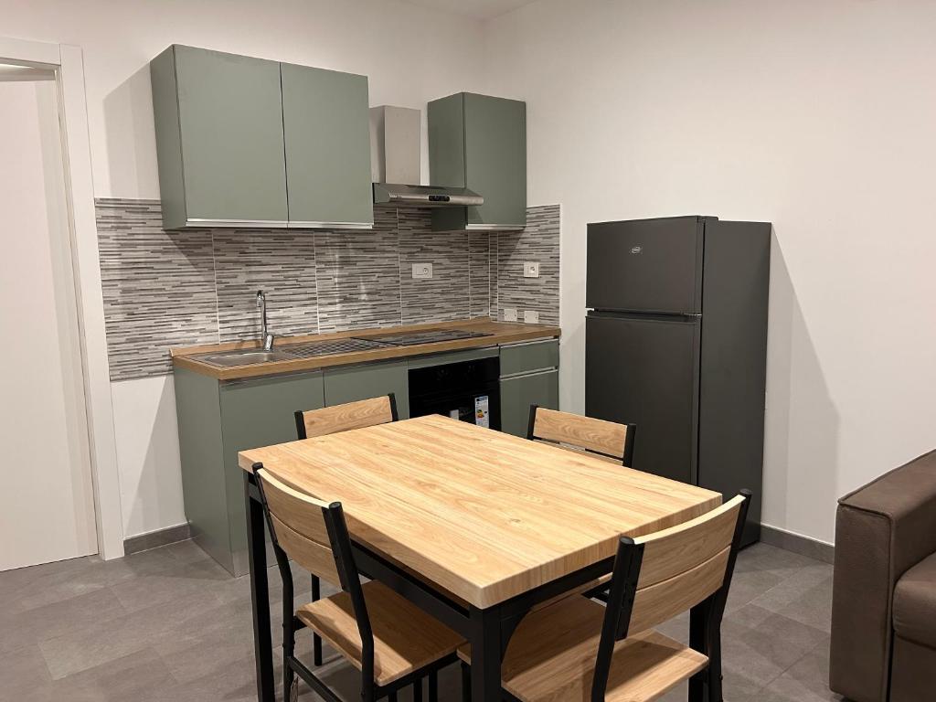 une cuisine avec une table en bois et un réfrigérateur dans l'établissement Emmeci House, à Alghero