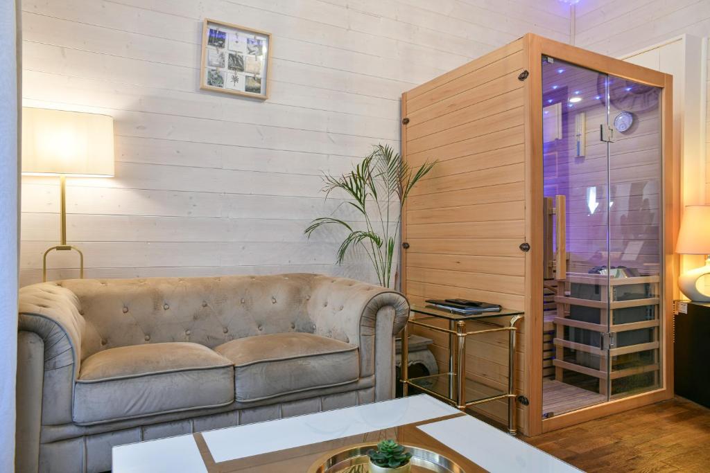 a living room with a couch and a table at Glamour Jacuzzi Privé Chambéry in Chambéry