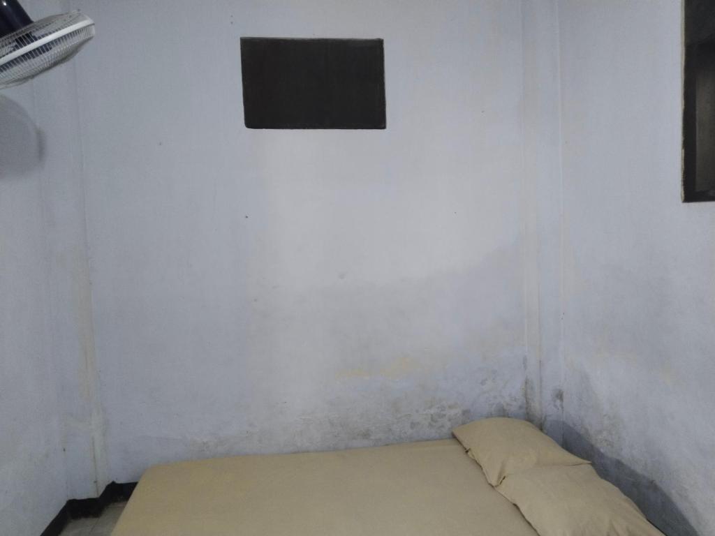 a small room with a bed and a window at Penginapan SALSA in Ketapang