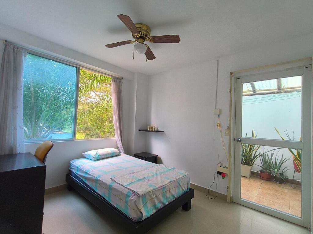 une chambre avec un lit et un ventilateur de plafond dans l'établissement Apartamento grande enfrente del océano, à Tonsupa