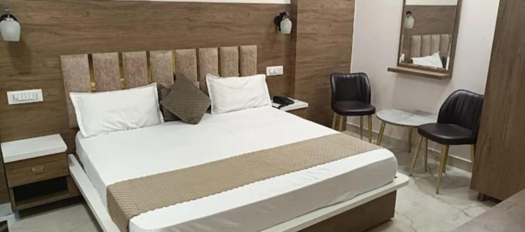a bedroom with a large bed with a wooden headboard at aluxor hotel and Restaurant in Kharar