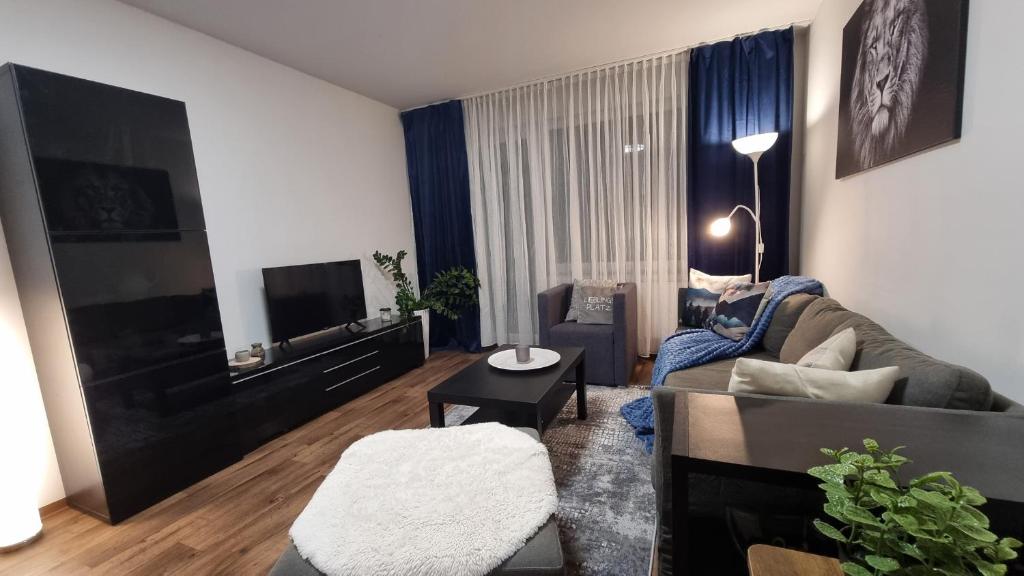 a living room with a couch and a tv at Family & Business Apartment Erlangen, Siemens & Uni Nähe in Erlangen