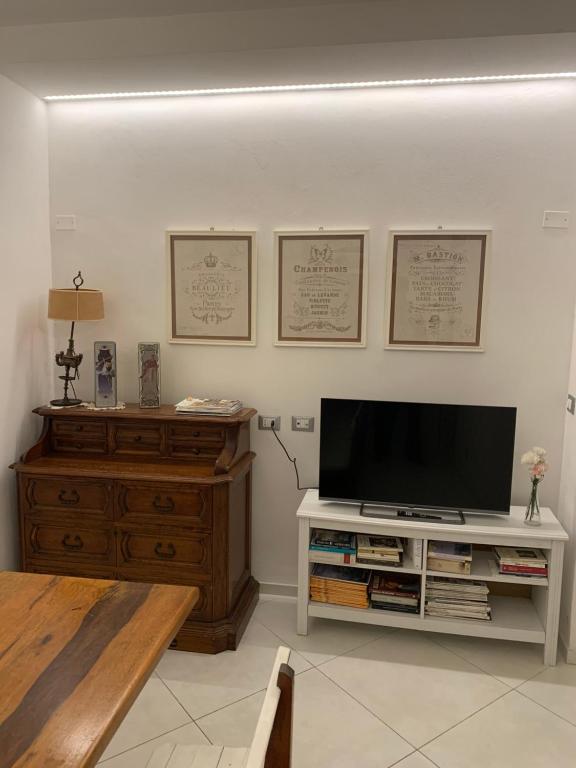 un salon avec une télévision à écran plat sur une commode en bois dans l'établissement Casa Due Cuori - Massa Centro, à Massa