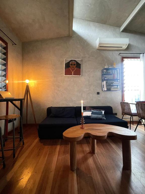 a living room with a couch and a table with a candle at The Urban Farm House in Accra