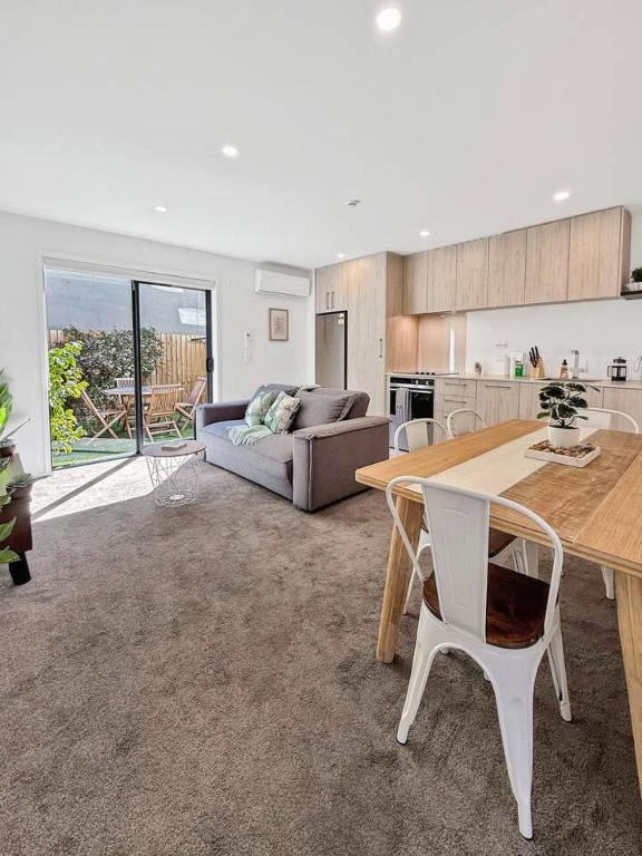 a living room with a table and a couch at Stylish 2-Bedroom Home with Front Yard in Linwood