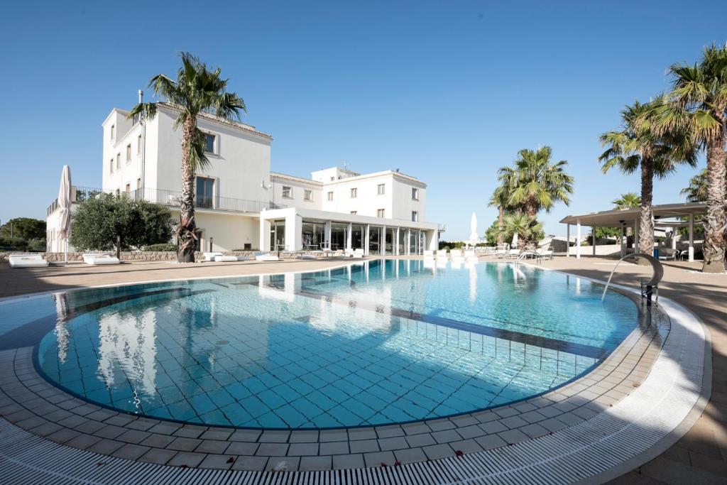 a large swimming pool in a large building at Pietre Nere Resort & Spa in Modica