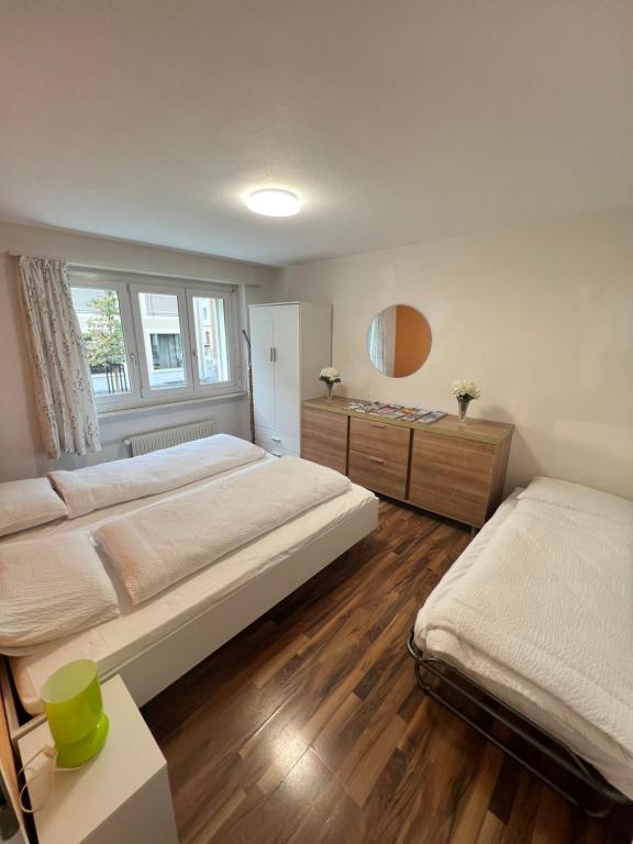 a large bedroom with two beds and a window at Perle Apartment in Interlaken