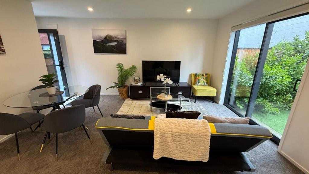 a living room with a couch and a table at Stylish Cashel Townhouse Stay in Linwood