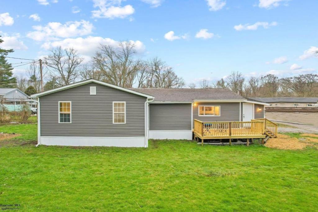 a house with a deck on a yard at Corporate Cottage on Circle in Thornville