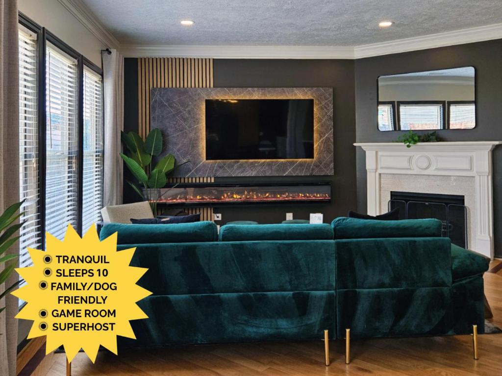 ein Wohnzimmer mit einer grünen Couch und einem Kamin in der Unterkunft Sleeps 10 Pet-friendly 4br Near Hospital in Lawrenceville