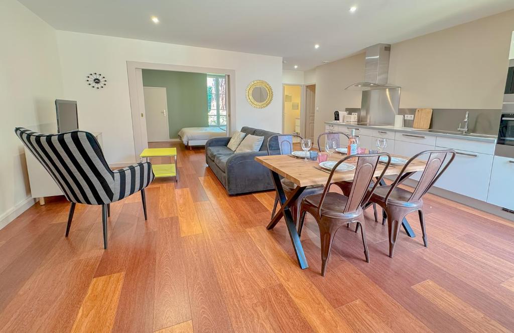 a kitchen and a living room with a table and chairs at Du soleil au balcon - Hypercentre in Lons-le-Saunier