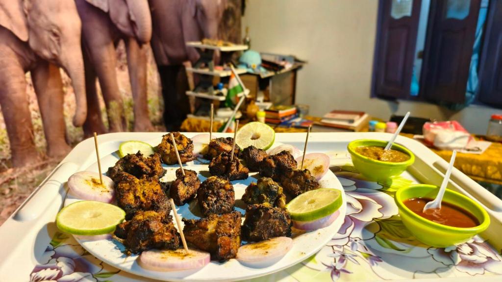 une assiette de nourriture sur une table avec des tranches de chaux dans l'établissement AALTAPORI HOMESTAY- BEST HOMESTAY in BUXA-JAYANTI, à Jayanti
