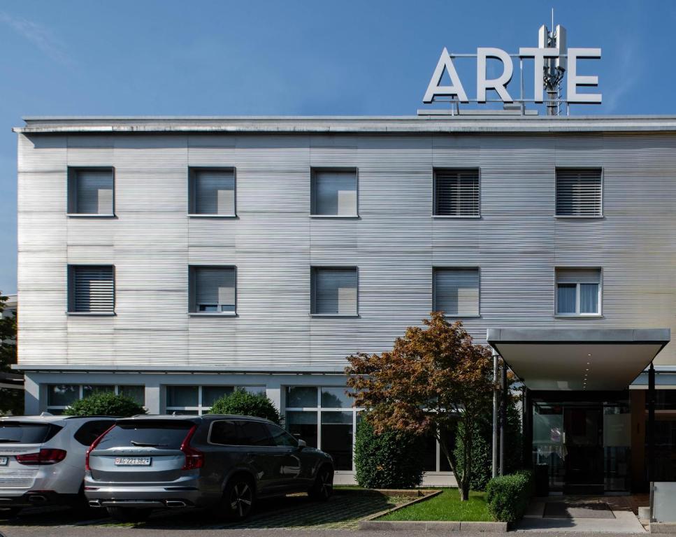 a building with cars parked in front of it at Hotel Arte Spreitenbach in Spreitenbach