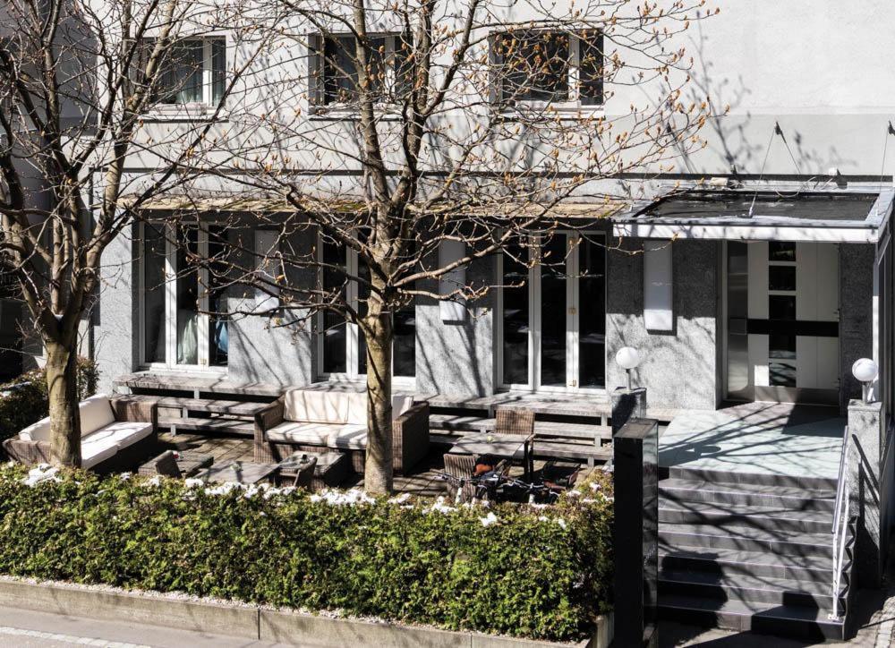 uma casa com bancos e uma árvore em frente em Self Check-In Hotel David 22 em St. Gallen