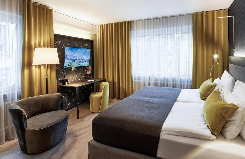 a hotel room with a bed and a chair at Sorell Boutique-Hotel Seefeld Zürich in Zurich