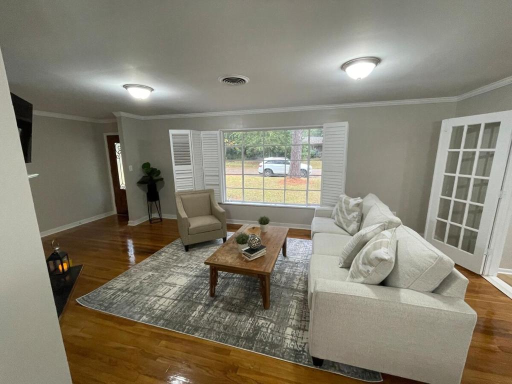 ein Wohnzimmer mit einer weißen Couch und einem Tisch in der Unterkunft Roomy 4BR Home with Fenced Yard in Jackson