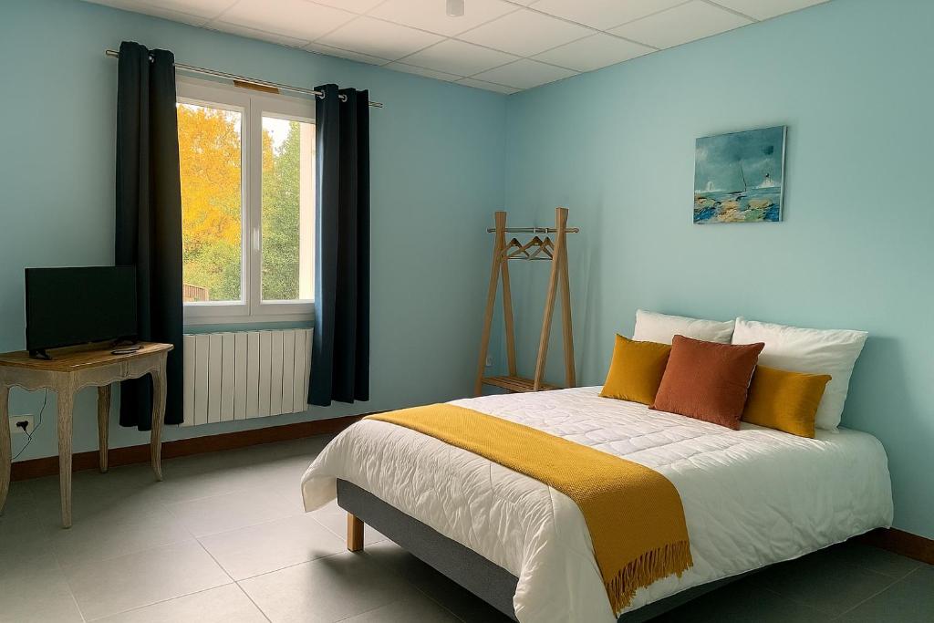a bedroom with a bed and a window at L'Arbre de Vie in Montmarault