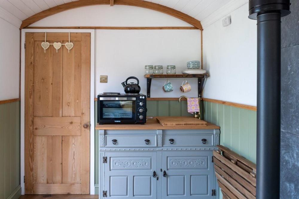 a room with a blue cabinet with a television on top at Shepherds hut in Kent