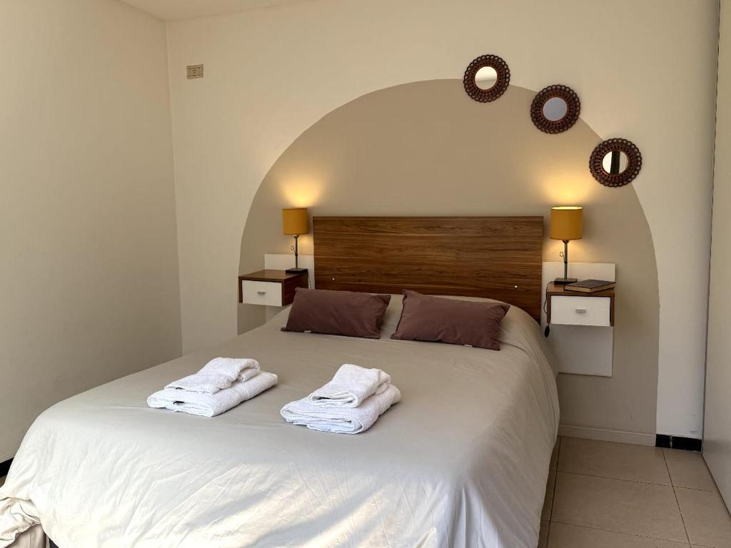 ein Schlafzimmer mit einem Bett mit zwei Handtüchern darauf in der Unterkunft CASA RUBÍ - ENCANTADOR APARTAMENTO EN MENDOZA - Cochera Privada y Seguridad Permanente in Guaymallen