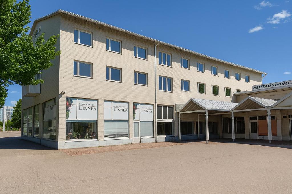 a large tan building with a store front with windows at Hotelli Vilho in Kotka