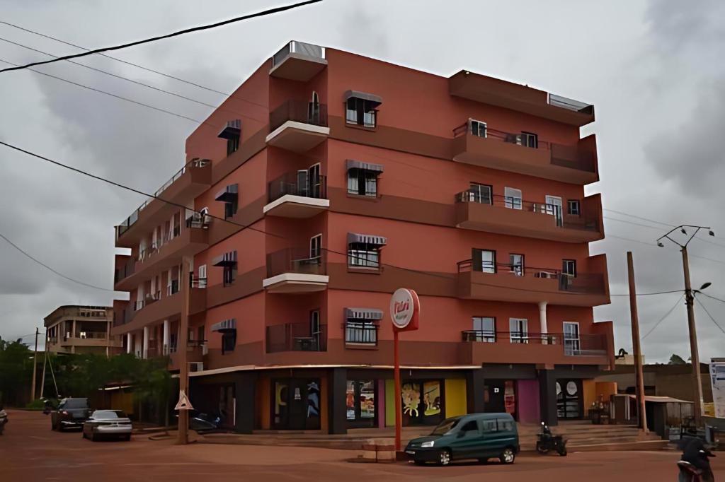 a red building with cars parked in front of it at AS Appartement meublé in Bamako